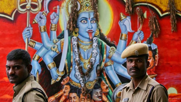 Policiais em frente a imagem da deusa hindu Kali, em templo em Hyderabad, Índia