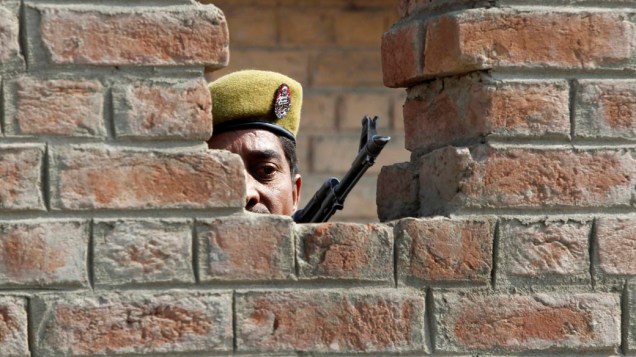 Policial mantem guarda em abrigo após explosão de granada em mercado na cidade de Srinagar, Índia