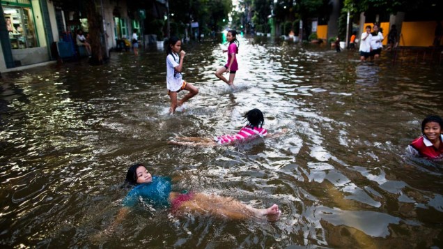 Garotas brincam em rua alagada em Bangcoc, Tailândia