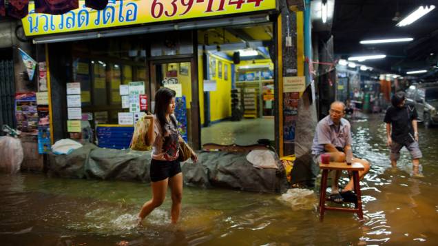 Tailandeses em rua alagada em Bangcoc, Tailândia