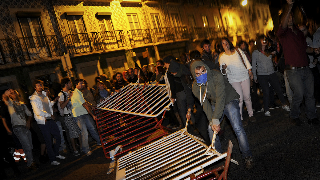 Manifestantes derrubam barricada que protegia o parlamento em Lisboa, durante protesto contra a previsão do orçamento de 2013 em Portugal