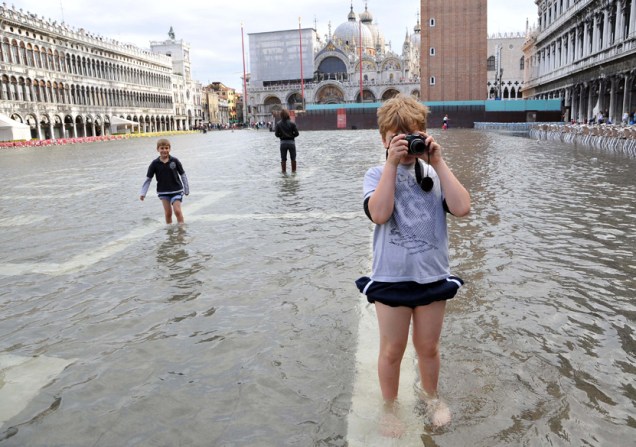 Em Veneza, crianças brincam na Praça de São Marcos, inundada com a alta da maré