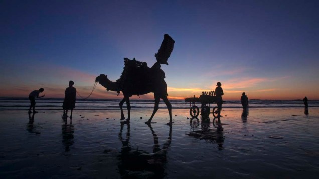 Comerciantes aguardam turistas na praia Clifton em Karachi, Paquistão