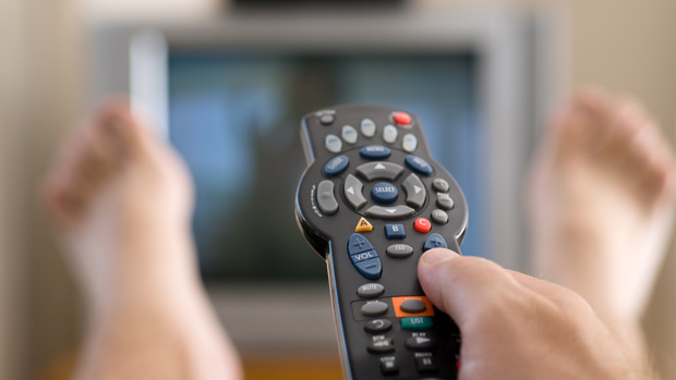 Homem com controle remoto na frente da TV
