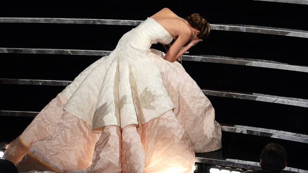 Jennifer Lawrence cai no caminho para receber a estatueta de melhor atriz do Oscar 2013