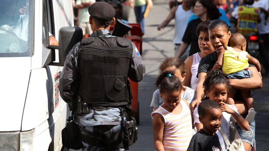 Moradores circulam normalmente, enquanto policiais do Batalhão de Choque monitoram as saídas da Rocinha, no Rio de Janeiro - 11/11/11