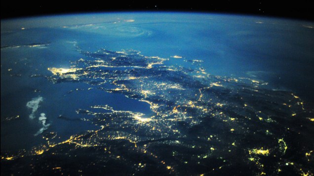 Visão noturna da Estação Espacial Internacional a cerca de 220 milhas acima da Terra olhando em direção ao sul do centro da Romênia sobre o Mar Egeu para a Grécia e inclui Salônica (perto do centro), a maior massa brilhante de Atenas (centro esquerda), e a capital macedônia de Skopje (inferior direito)