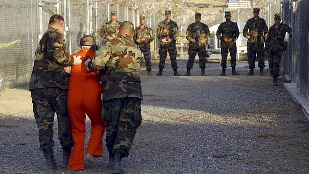 Soldados americanos escoltam preso em Guantánamo