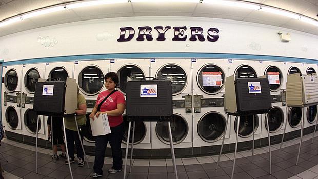 Eleitores republicanos depositam voto em cabine de votação improvisada em lavanderia de Illinois