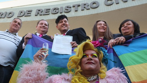 O comerciante Luiz André, de 37 anos, e o cabeleireiro José Sérgio, de 29 anos, ambos de terno preto, são o primeiro casal gay a obter a certidão de casamento civil no Brasil