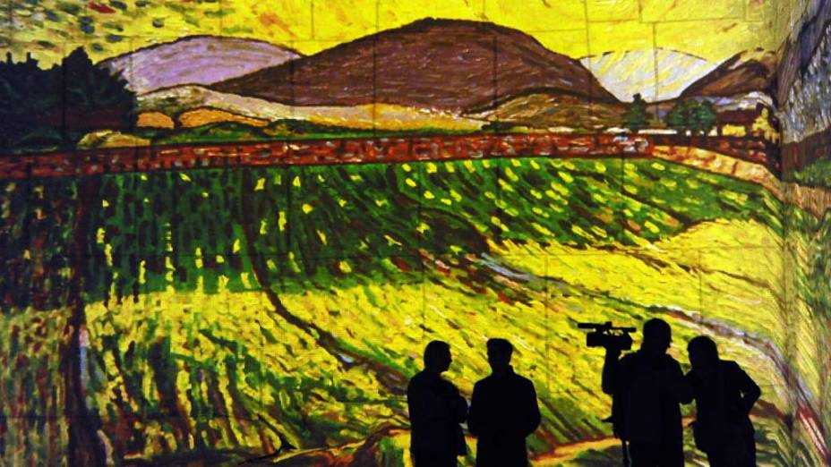 Visitantes em instalação audiovisual com projeções de pinturas de Paul Gauguin e Vincent van Gogh em Baux-de-Provence, França