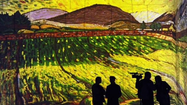 Visitantes em instalação audiovisual com projeções de pinturas de Paul Gauguin e Vincent van Gogh em Baux-de-Provence, França