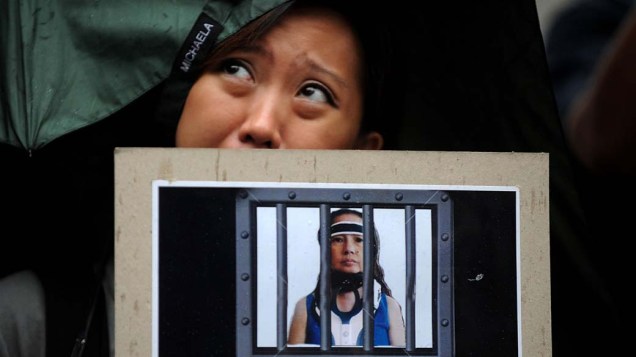 Manifestante segura imagem da ex-presidente Gloria Arroyo durante protesto em frente a Suprema Corte de Manila, nas Filipinas