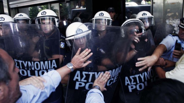 Em Atenas, conflito entre policiais e manifestantes em frente ao Ministério das Finanças. O ministro anunciou que a Grécia receberá outra parcela da ajuda da dívida até o próximo mês