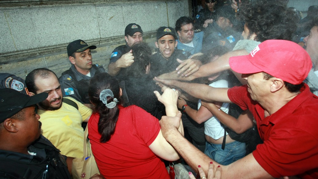 Manifestantes, bombeiros e policiais na entrada da Alerj, durante a votação do projeto que autoriza o estado a gerir a saúde por meio de Organizações Sociais