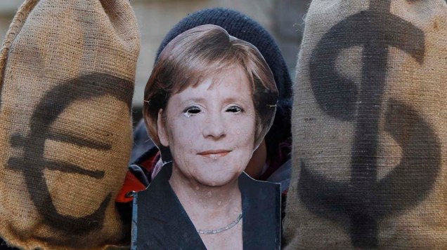 Manifestante com máscara da chanceler alemã Angela Merkel em protesto em Munique