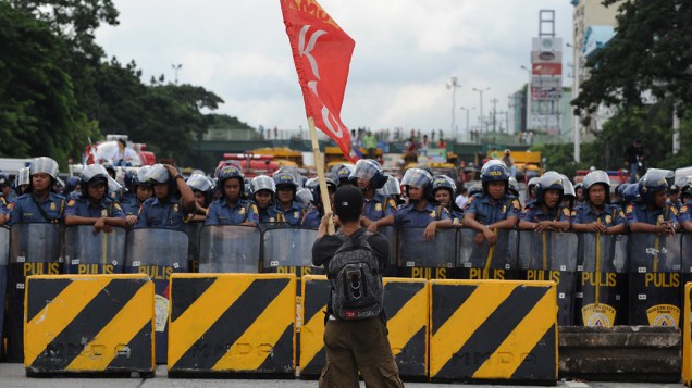 Manifestante anti-governo enfrenta policiais durante uma manifestação contra o presidente filipino Benigno Aquino em Manila