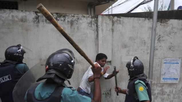 Em Bangladesh, policiais repreendem manifestante. Milhares de trabalhadores do setor de vestuário entraram em greve, bloqueando estradas e saqueando lojas e fábricas após não haver acordo de reajuste salarial entre os grevistas e o governo