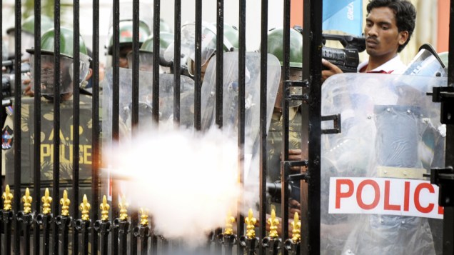 Policiais atiram bomba de gás lacrimogênio contra manifestantes que buscam a separação de Telangana em Hyderabad, Índia