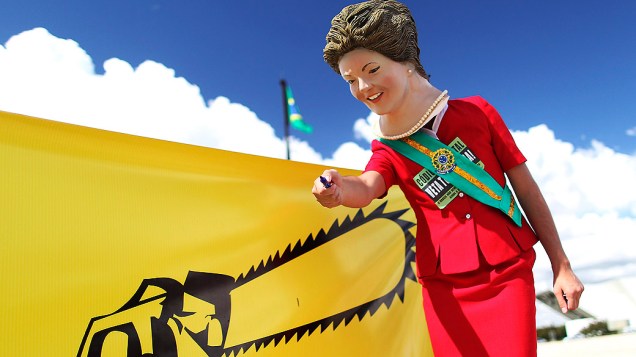 Ativista com uma máscara da presidente Dilma Rousseff participa de protesto em Brasília que pedia veto ao Código Florestal