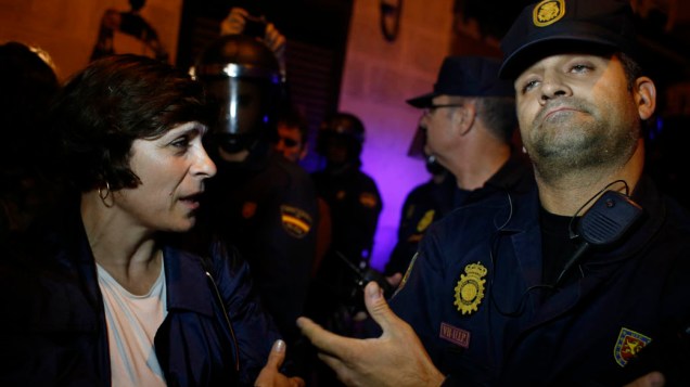 Manifestante discute com policial durante protesto em Madri