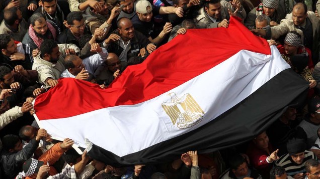 Manifestantes carregam bandeira do Egito durante protesto no centro do Cairo