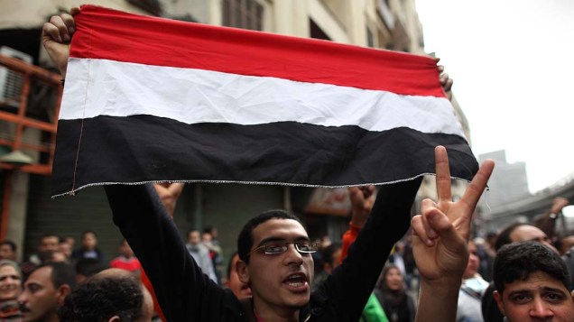 Manifestante com a bandeira egípcia durante confronto com a polícia - 28/01/2011