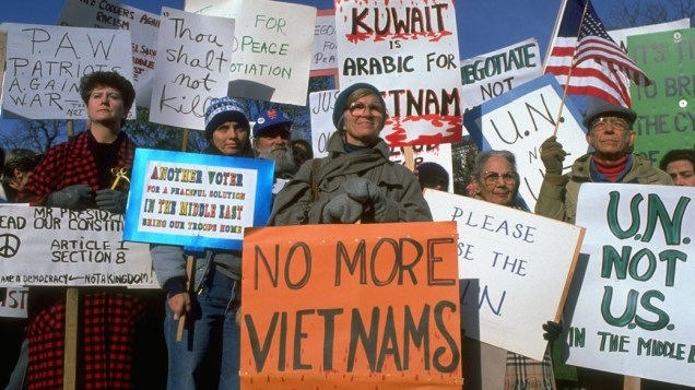 Multidão protesta contra a intervenção militar dos EUA  no Golfo Pérsico. Alguns relembram a Guerra do Vietnã com cartazes "Chega de Vietnãs", conflito que matou mais de 40 mil soldados americanos