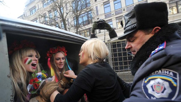 Policial prende integrantes de movimento feminista durante protesto denominado “Itália não é bordel” na cidade de Kiev. As  manifestações questionam o escândalo sexual envolvendo o primeiro ministro italiano Silvio Berlusconi