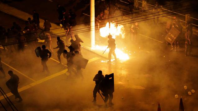 Tropa de choque utiliza gás lacrimogêneo durante um protesto em uma rua perto do estádio do Maracanã do Rio de Janeiro