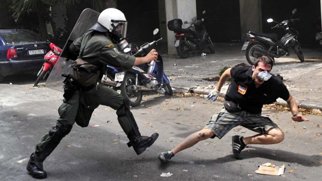 Manifestante em conflito com a polícia no centro de Atenas, Grécia