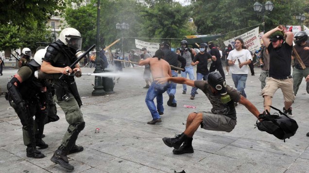Manifestantes durante conflito com a polícia no centro de Atenas, Grécia. Os manifestantes pedem a derrubada de um pacote de medidas de austeridade, que deve aumentar os impostos e privatizações no país