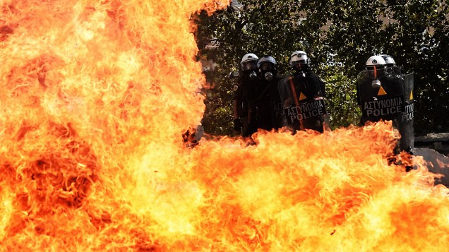 Grevistas lançam coquetéis molotov contra a polícia perto do Partido Comunista grego, em Atenas, nesta quinta-feira(18)