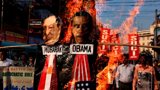 Manifestantes colocam fogo em imagens de Barak Obama e Hosni Mubarak, durante protesto em favor da renúncia do presidente egípcio no centro de Calcutá, Índia