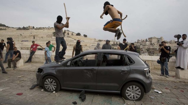 Jovens destroem carro em Jerusalém durante manifestação no enterro de um palestino morto pelo exército israelense
