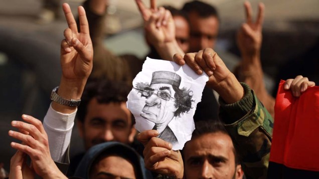 Manifestantes com caricatura de Muamar Kadafi durante protestos em Tobruk