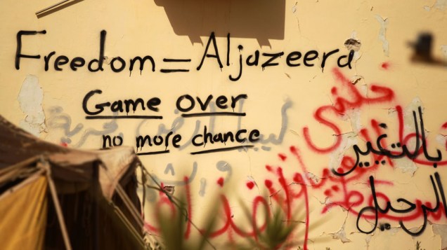Pichações em muro na cidade de Tobruk compara canal de notícias Al-Jazeera com a palavra "liberdade", na Líbia