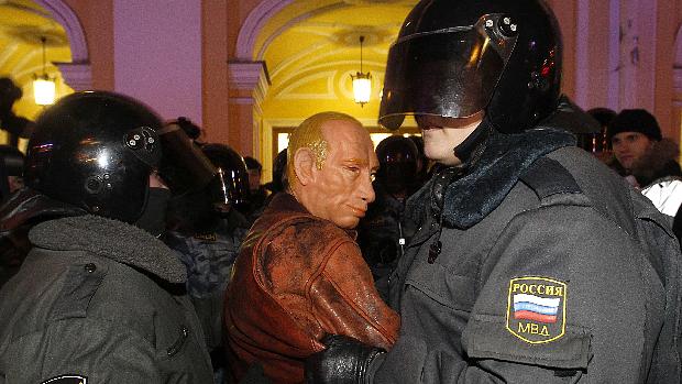 Polícia russa detém manifestante usando máscara com o rosto do premiê Vladimir Putin