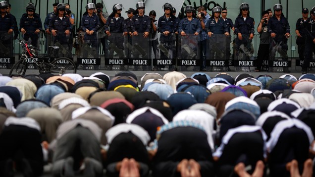 Policiais em guarda em frente a embaixada americana onde manifestantes mulçumanos protestam contra o filme Inocência dos mulçumanos em Bangcoc, Tailândia