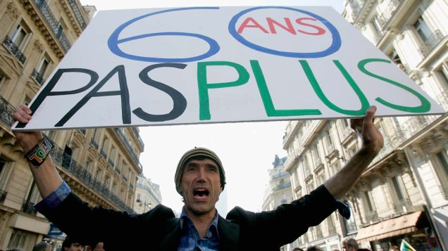 Com um cartaz escrito “60 anos não mais”, homem protesta nas ruas de Paris contra reforma da previdência proposta pelo governo francês