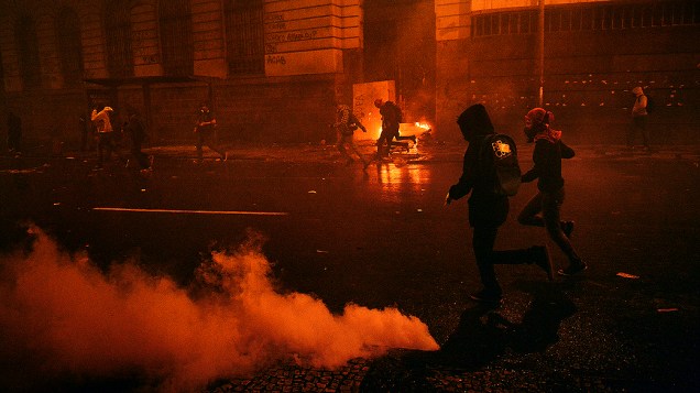 Rio de Janeiro - Manifestantes correm em meio a bombas de gás lacrimogêneo disparadas pela polícia na sequência de confrontos após manifestação pacífica de professores ser invadida por grupo de mascarados - (07/10/2013)