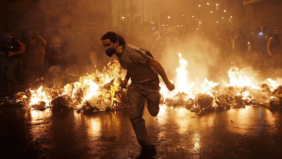 Rio de Janeiro - Um manifestante do Black Bloc corre para fora da Assembleia Municipal durante um protesto em apoio a greve dos professores - (07/10/2013)