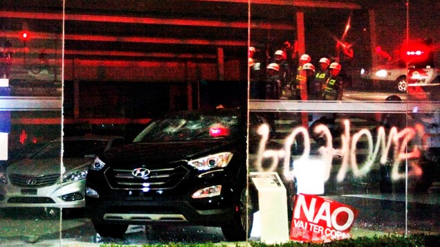 Carros de concessionárias que ficam nos arredores da avenida Paulista são danificados por manifestantes durante protesto contra os gastos na Copa, nesta quinta-feira (15)