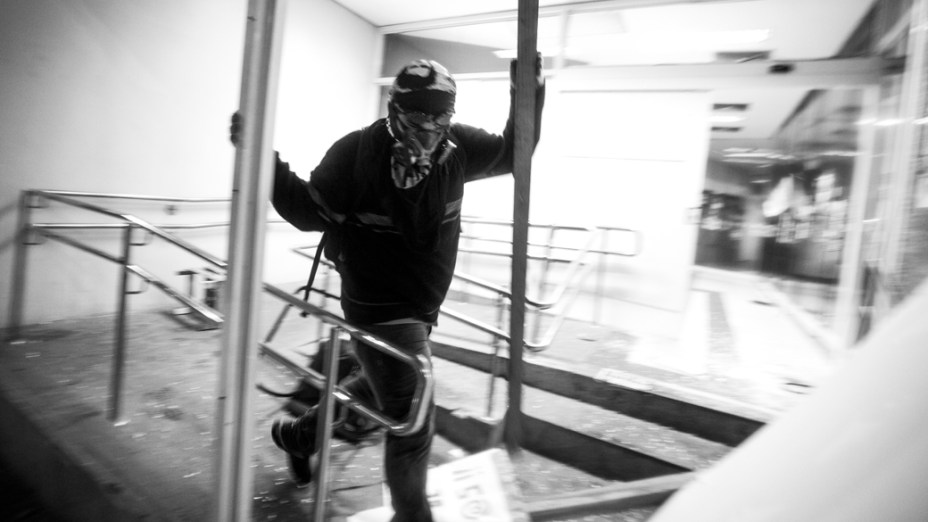 Manifestantes mascarados que se infiltraram no protesto pacífico dos professores, destruíram caixas eletrônicos de uma agência bancária no centro