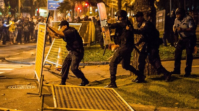 Policial recoloca gradil derrubado por manifestantes que isola área do Palácio Guanabara
