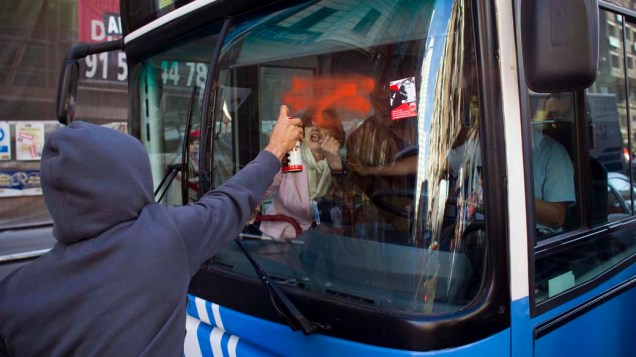 Manifestante picha ônibus durante greve geral em Madri para protestar contra medidas de austeridade do governo
