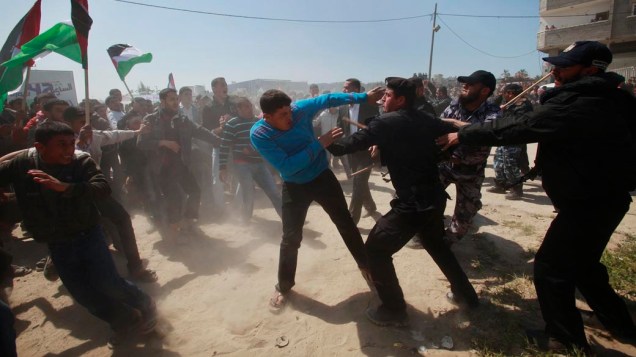Membros das forças de segurança do Hamas impediem manifestantes palestinos de se aproximarem da fronteira entre Israel e o norte da Faixa de Gaza no "Dia da Terra"