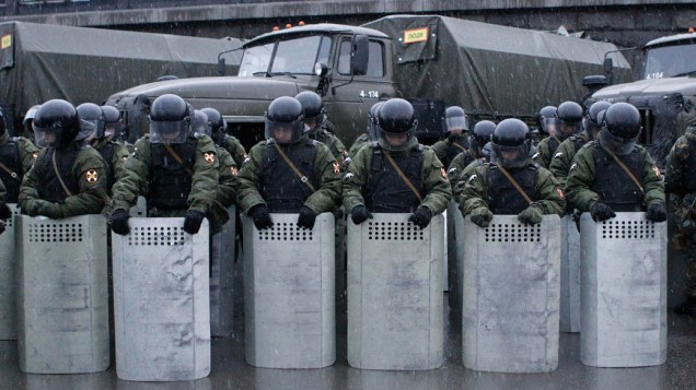 Tropa de choque da policia russa observa manifestantes, durante protestos em Moscou - 10/12/2011