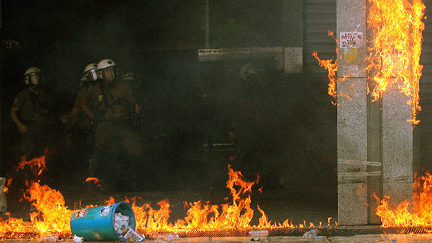 Policiais observam estragos após protestos, em Atenas. Manifestantes se reuniram na praça Syntagma, em frente ao Parlamento