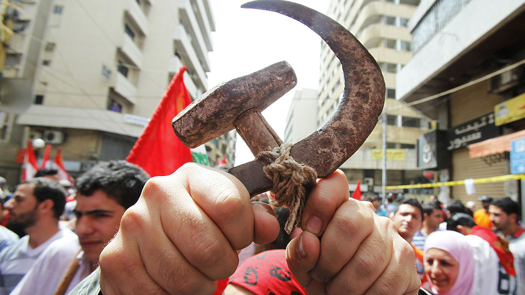 Ativista de esquerda libanês exibe a foice eo martelo, símbolos do comunismo, durante uma manifestação para marcar o Dia do Trabalho em Beirute